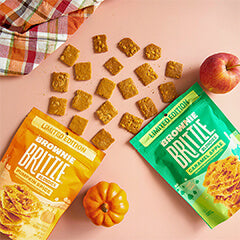 2 brownie brittle pouches with apple and pumpkin next to it