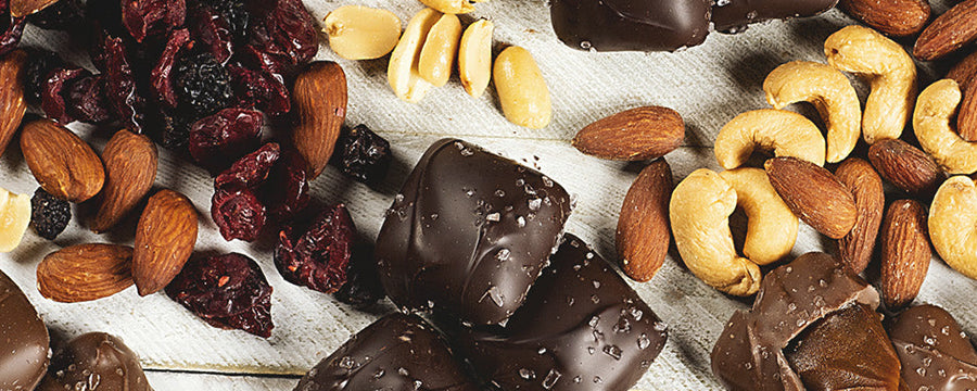various sanders candys and various nuts on a white wooden table