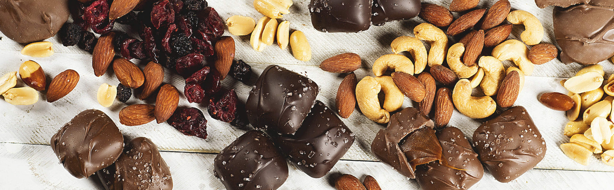 various sanders candys and various nuts on a white wooden table