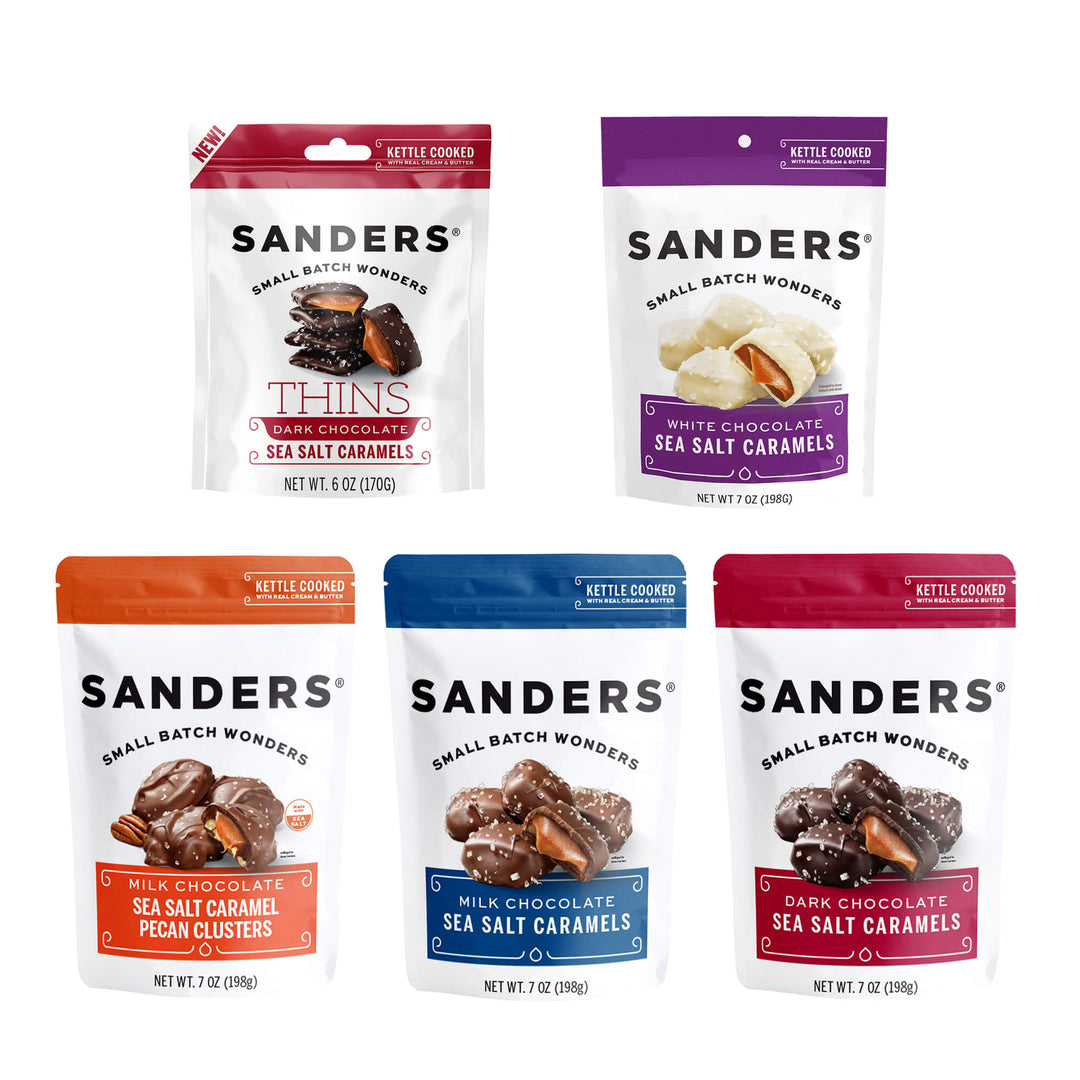 Five Sanders chocolates in the gift box assortment: dark chocolate caramel thins, white chocolate sea salt caramels, milk chocolate pecan clusters, and milk and dark chocolate sea salt caramels.
