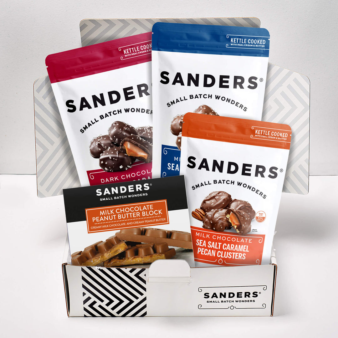 Sanders Chocolate Lovers 4-item gift box with milk and dark chocolate sea salt caramels, pecan clusters, and peanut butter blocks.