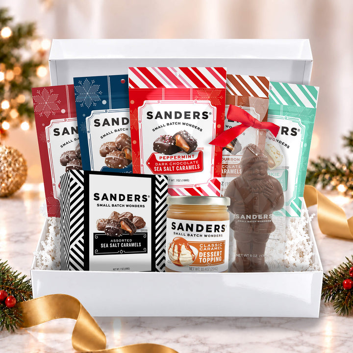 Sanders Deluxe Holiday Indulgence 8-item gift box with assorted chocolates, sea salt caramels, dessert topping, and chocolate Santa.