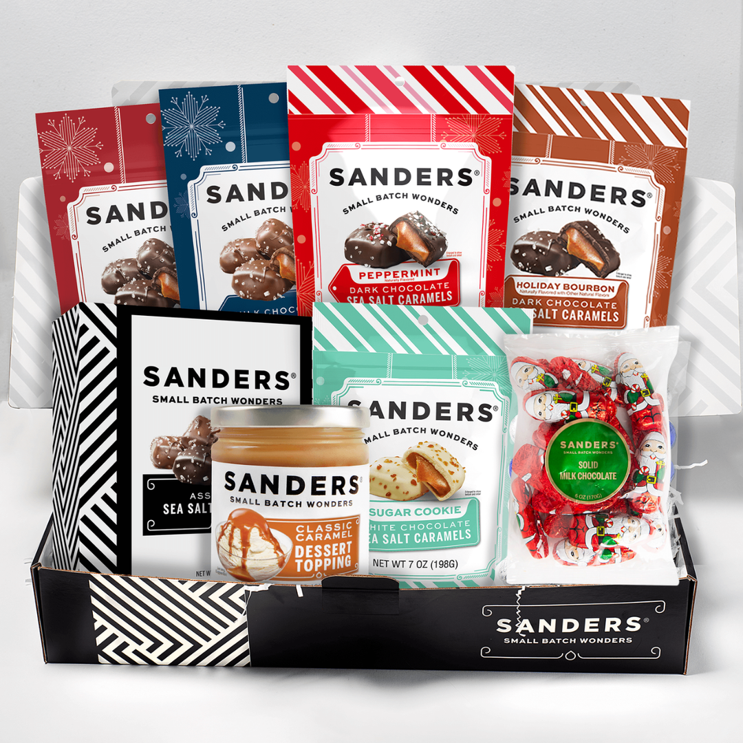 Collection of Sanders candy and dessert topping packages in a box on a white background