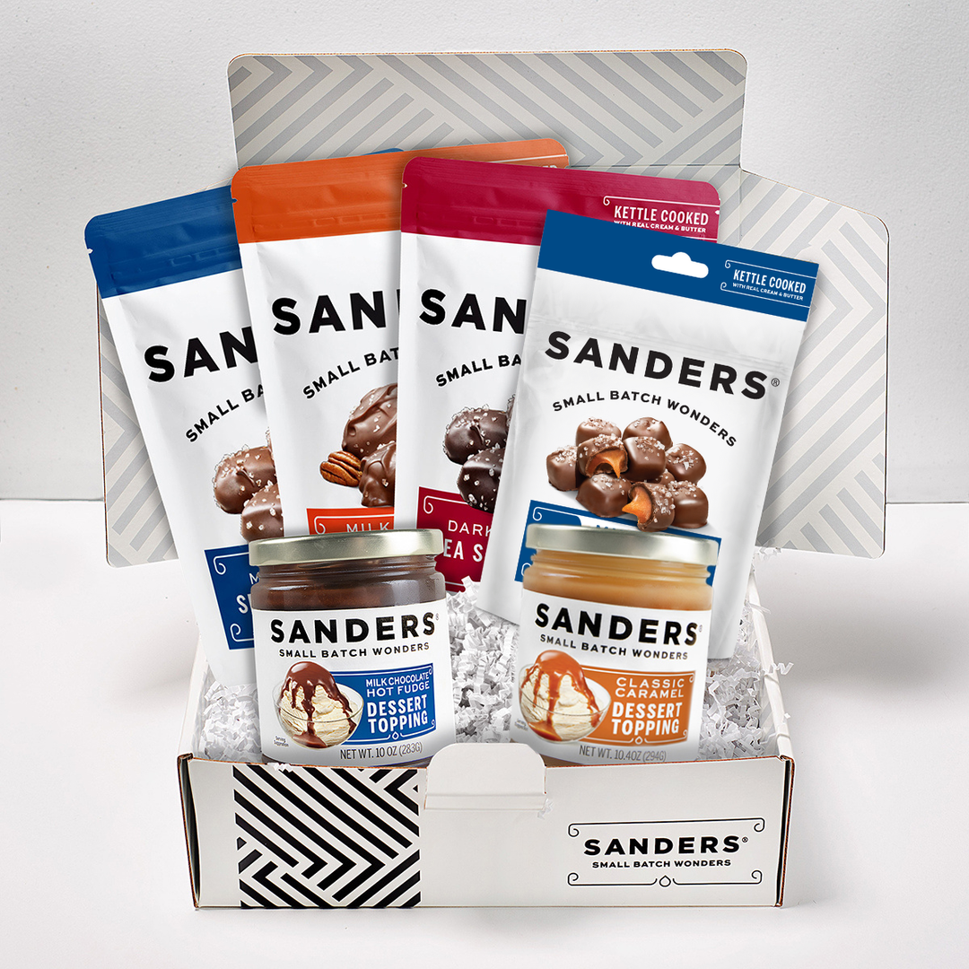 Collection of Sanders dessert topping packages in a display box on a white background